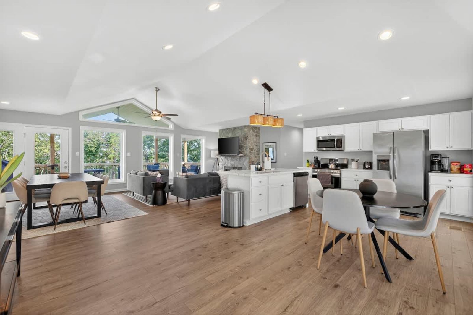 Open-concept kitchen, dining and living area under a vaulted ceiling
